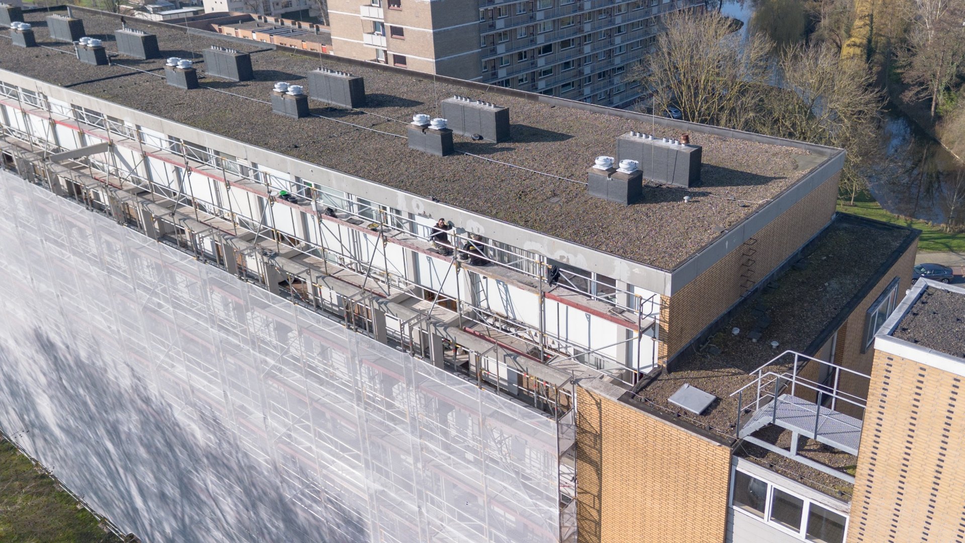 Werkzaamheden op de steiger langs de bovenste verdieping en dakrand van Bosseplantsoen
