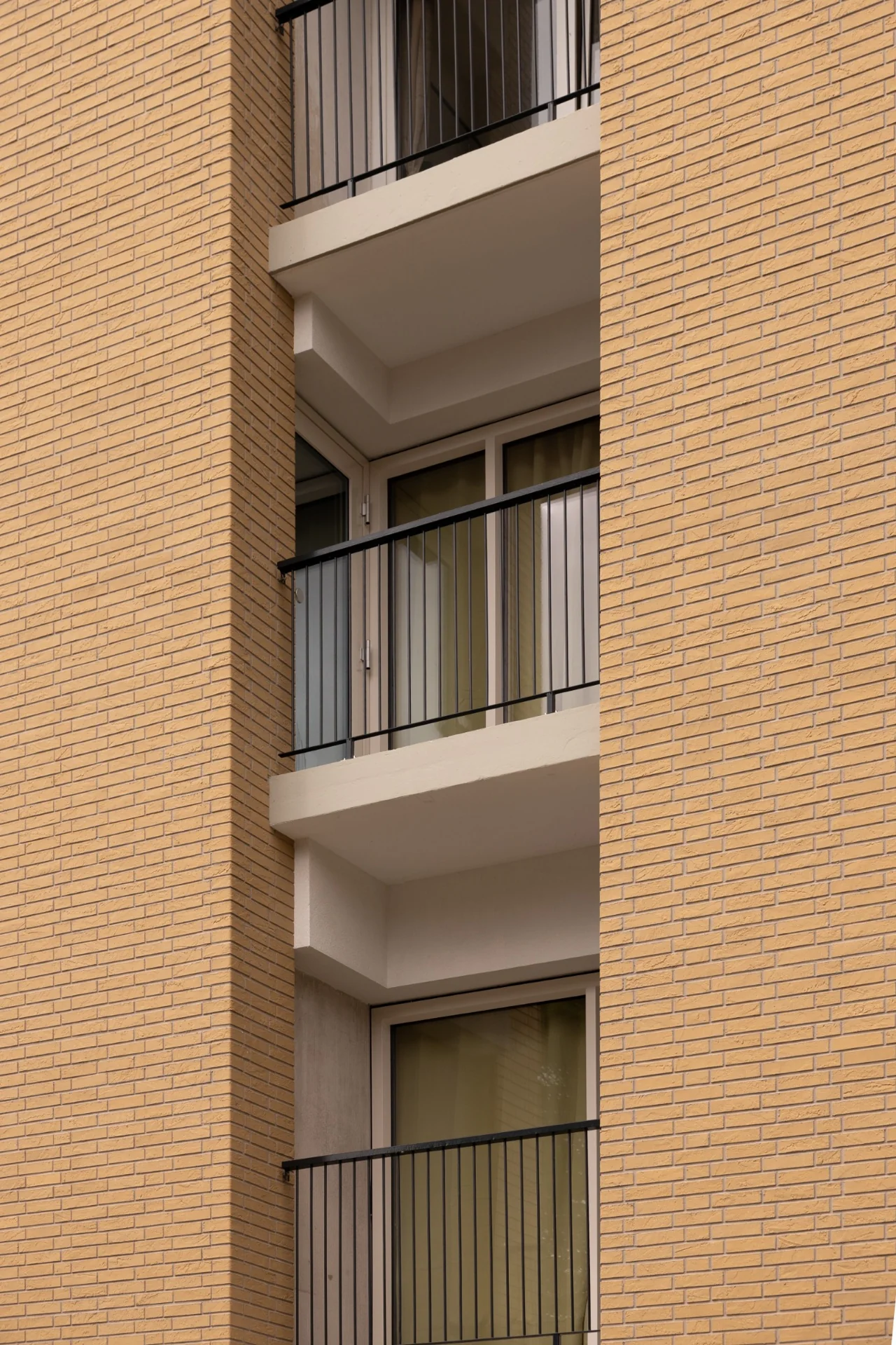 Detail van de vernieuwde gevel, lichte balkonranden en zwarte balustrades van Bosseplantsoen
